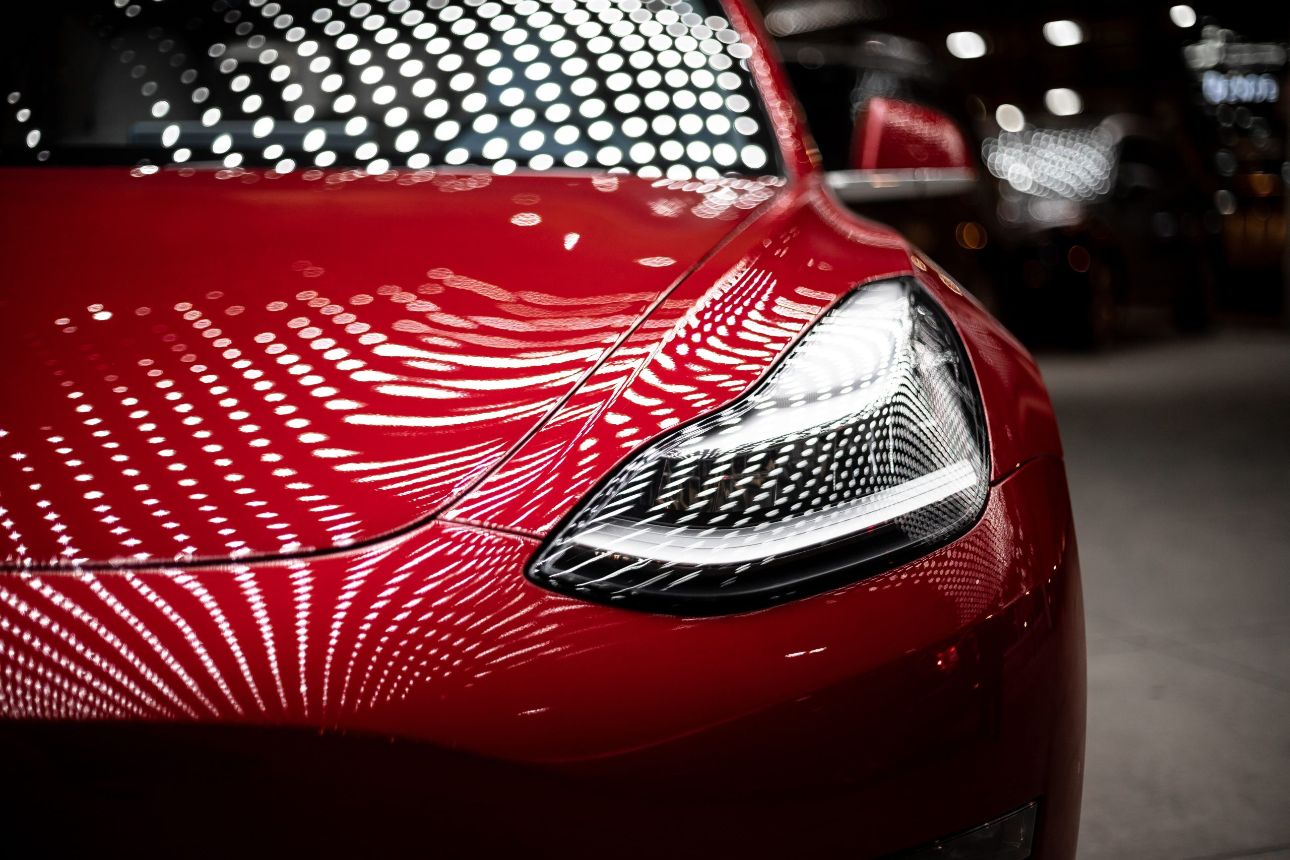 red tesla model 3 front end headlight close up